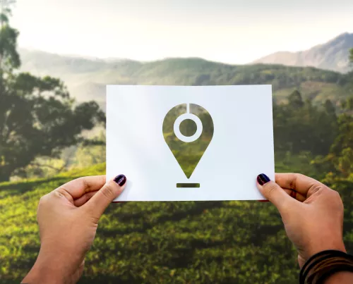 Feuille blanche tenue par deux mains de femmes, devant un paysage de campagne. Au centre de la feuille blanche, en pochoir, un picto &laquo; position &raquo; qui laisse voir le paysage.